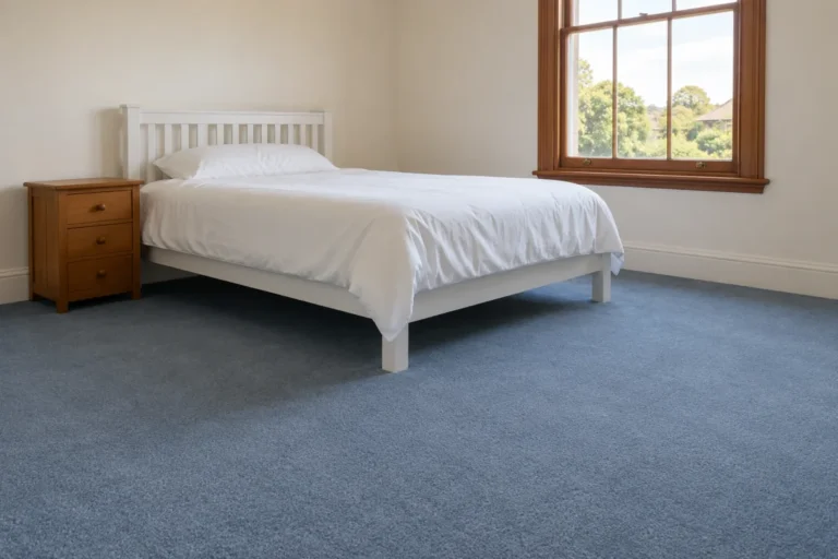 Clean blue carpet in a bright bedroom with a white bed and timber window – carpet cleaning in Melbourne