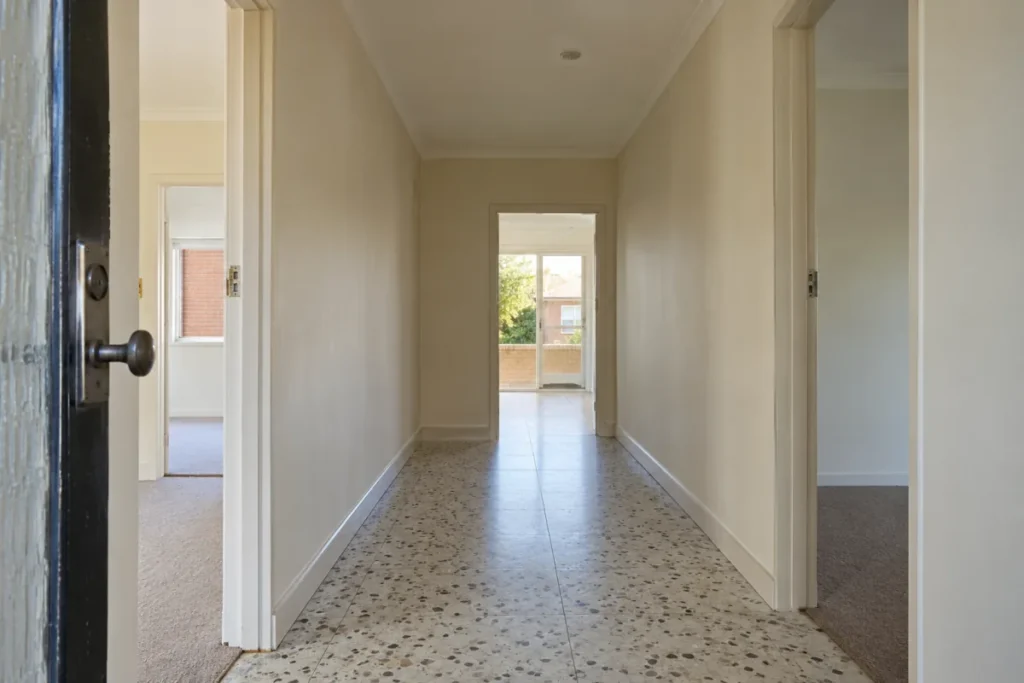 Empty hallway with a clean terrazzo floor leading to an open back door – end of lease cleaning in Essendon