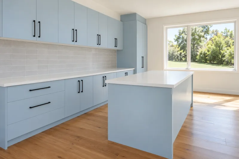 Clean pale blue kitchen with an island bench and timber floor in an empty room – end of lease cleaning in Greensborough