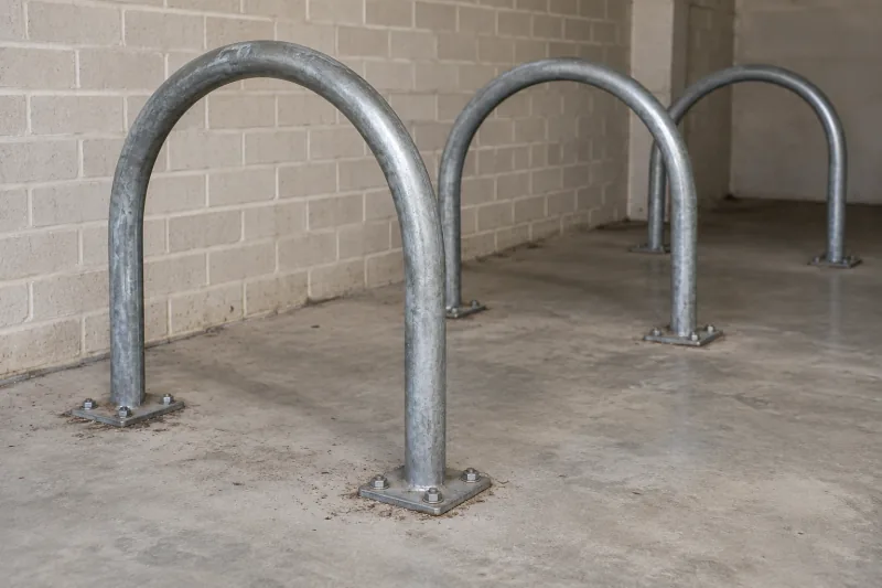 Steel hoop bike racks with dirt around their bases on a concrete floor – strata cleaning in Molonglo Valley